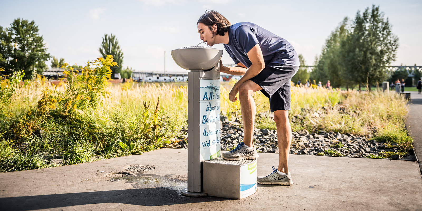 Läufer erfrischt sich am Trinkbrunnen