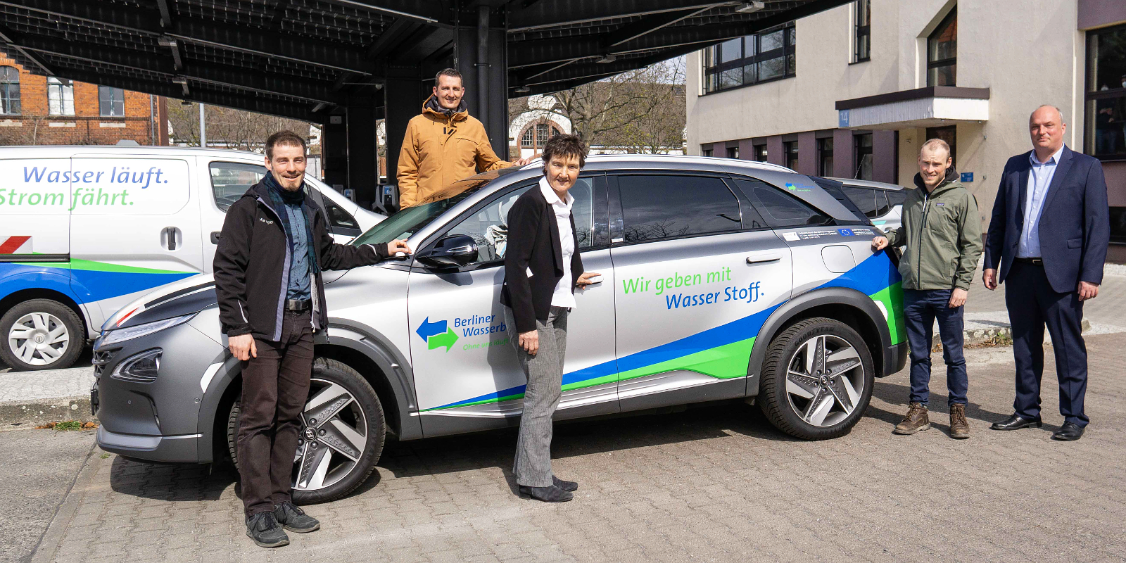 Projektteam steht vor einem Wasserstofffahrzeug