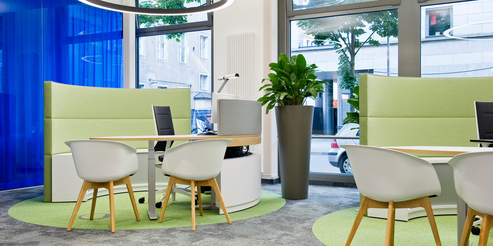 Ambiente des Kundenzentrums mit blau-grünem Mobiliar