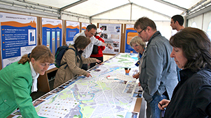 Besucher auf dem Umweltfestival betrachten Karte