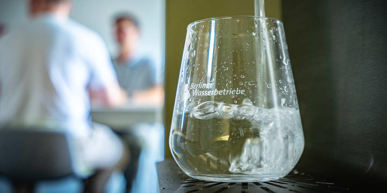 Wasserspender  zapft frisches Trinkwasser in ein Glas