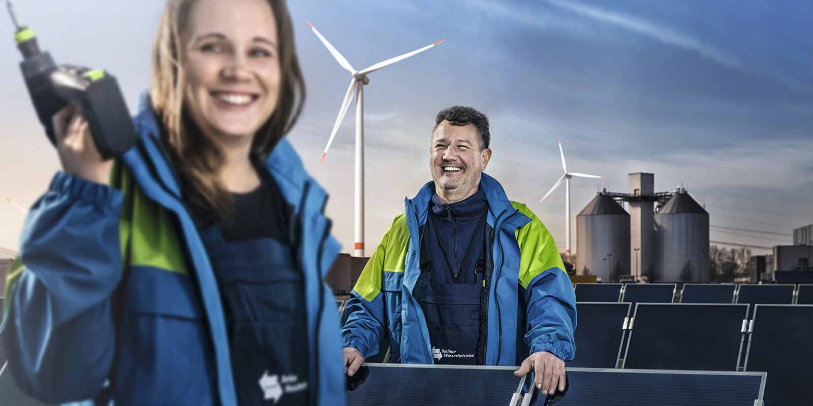 Zwei MitarbeiterInnen der Wasserbetriebe vor einem Windrad