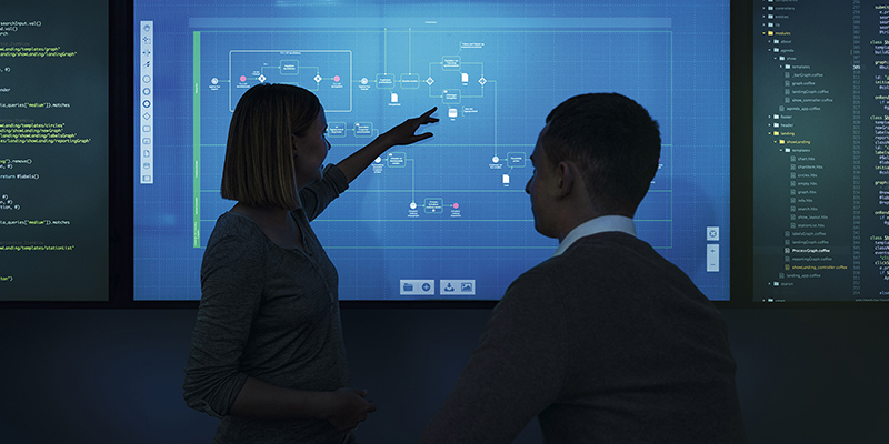 Zwei Personen stehen vor einem Touchscreen