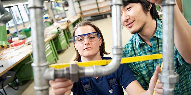 Auszubilldende helfen sich bei der Arbeit