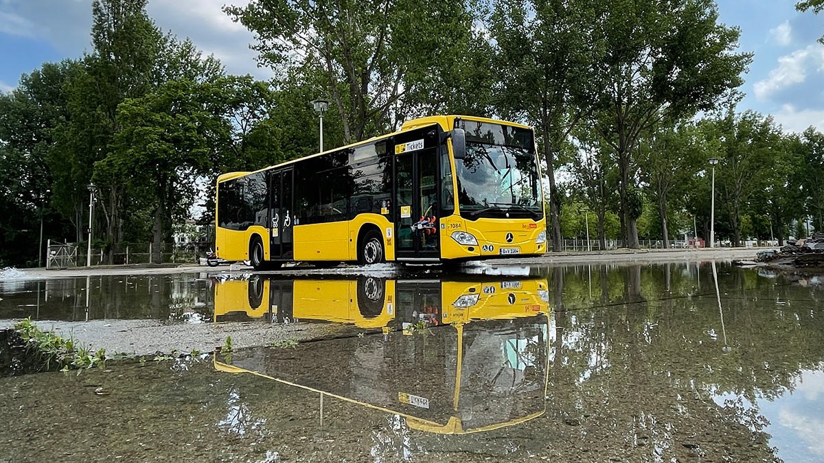 Bus der BVG spiegelt sich in einer Pfütze